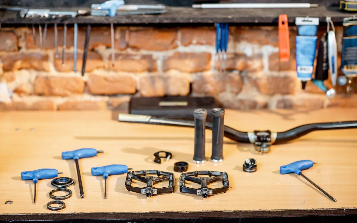 Workshop bench with pedals, Allen keys and bike parts