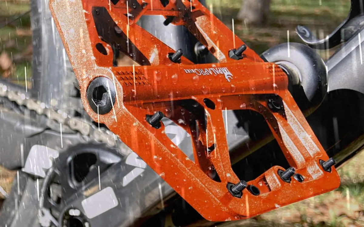 Orange flat pedal with pins in the rain